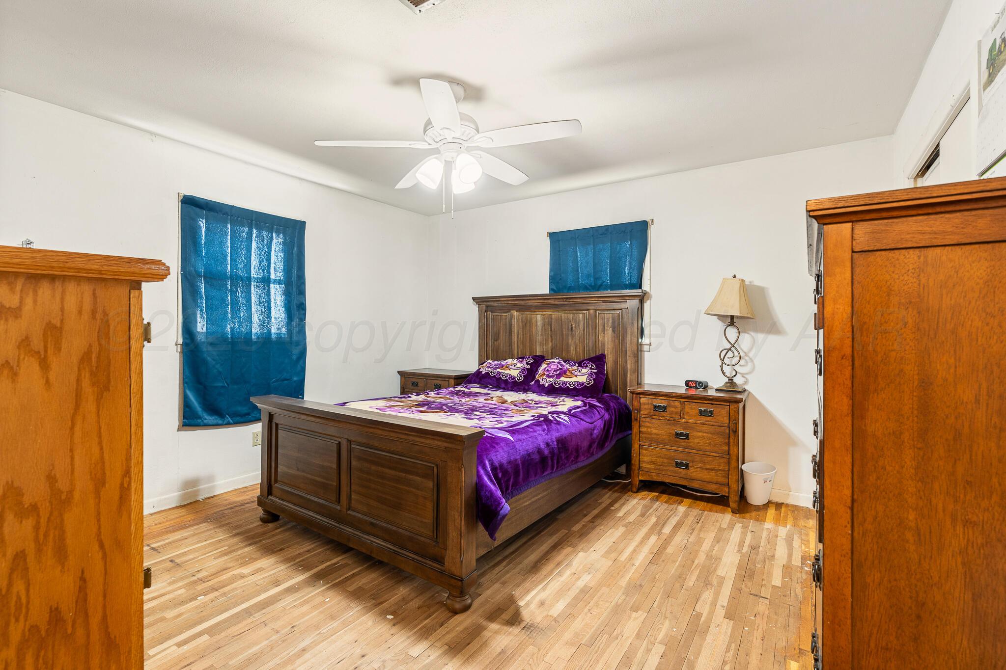 1790 Farm To Market Road 145 Hart, TX 79043 - Photo 13 of 28 a bedroom with a bed and a chandelier