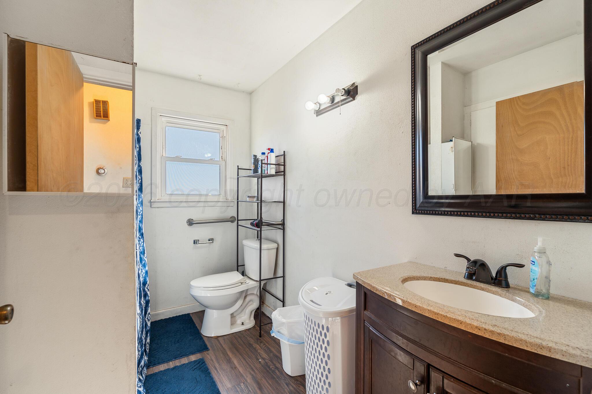 1790 Farm To Market Road 145 Hart, TX 79043 - Photo 14 of 28 a bathroom with a granite countertop toilet sink and mirror