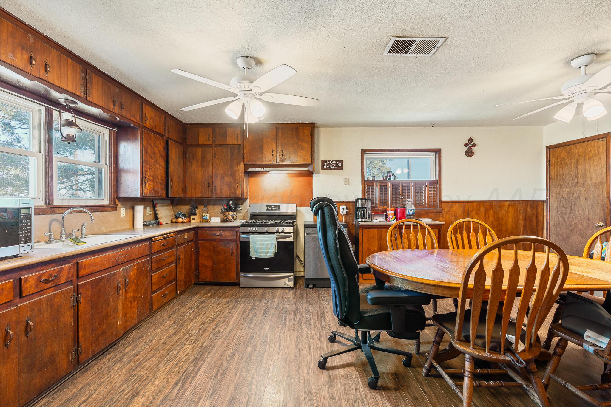 1790 Farm To Market Road 145 Hart, TX 79043 - Photo 17 of 28 a kitchen with a table chairs sink and cabinets