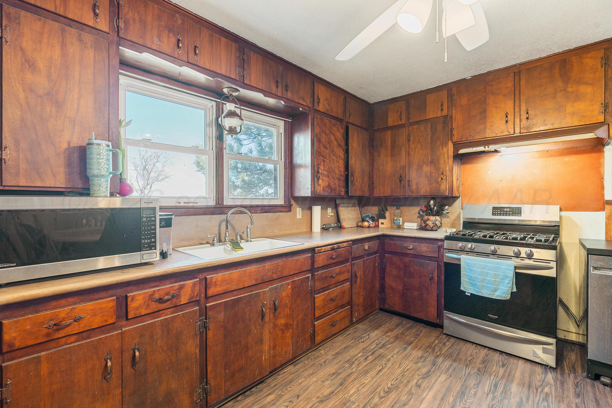 1790 Farm To Market Road 145 Hart, TX 79043 - Photo 20 of 28 a kitchen with stainless steel appliances granite countertop a sink stove and cabinets