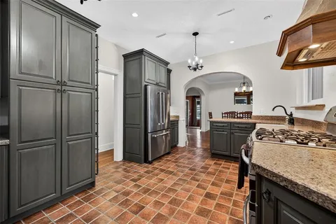 a kitchen with stainless steel appliances granite countertop a refrigerator a stove and a sink