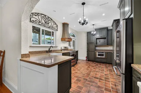 a kitchen with stainless steel appliances granite countertop a sink a stove and a refrigerator