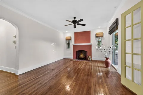 a view of a livingroom with wooden floor a fireplace and a chandelier