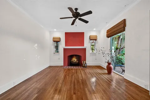 a living room with a fireplace and wooden floor
