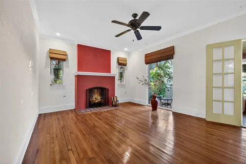 a view of a livingroom with a fireplace wooden floor and a window
