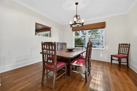 a dining room with furniture a chandelier and wooden floor