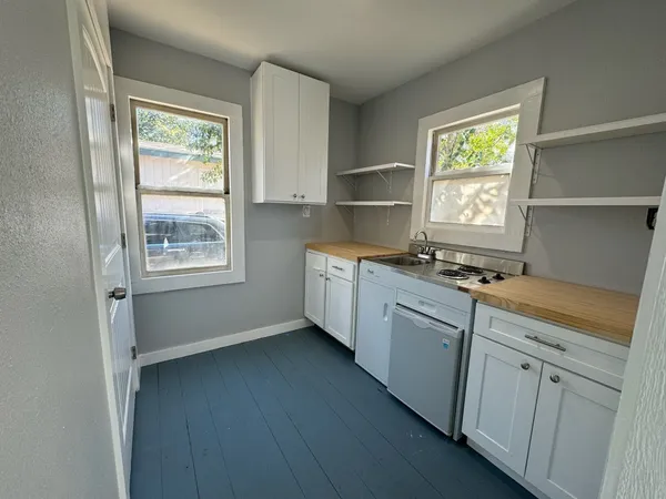 a kitchen with a sink cabinets appliances and a window
