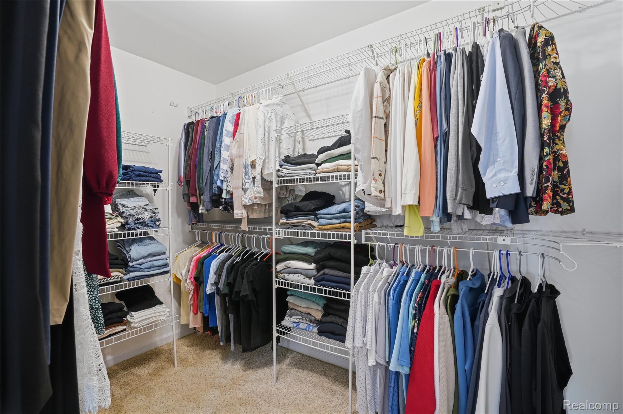 7217 Andersonville Road Clarkston, MI 48346 - Photo 26 of 65 Walk-in closet featuring carpet flooring, white wire shelving, and multiple hanging rods for organization