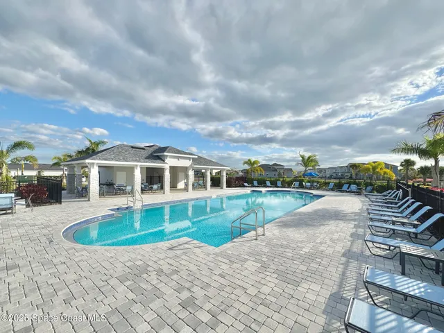 a front view of a house with swimming pool and sitting area