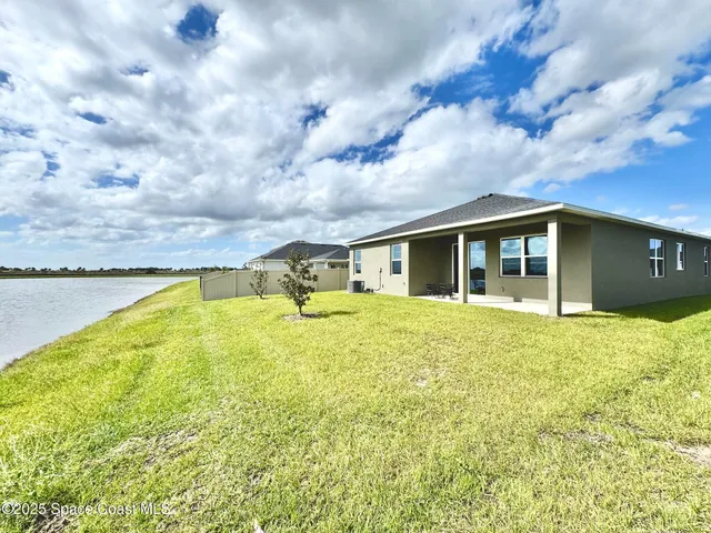 a view of a house with a swimming pool and a yard