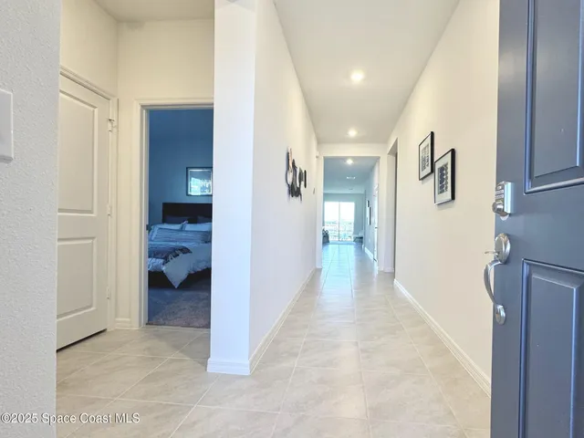 a view of a hallway with a livingroom and a chandelier