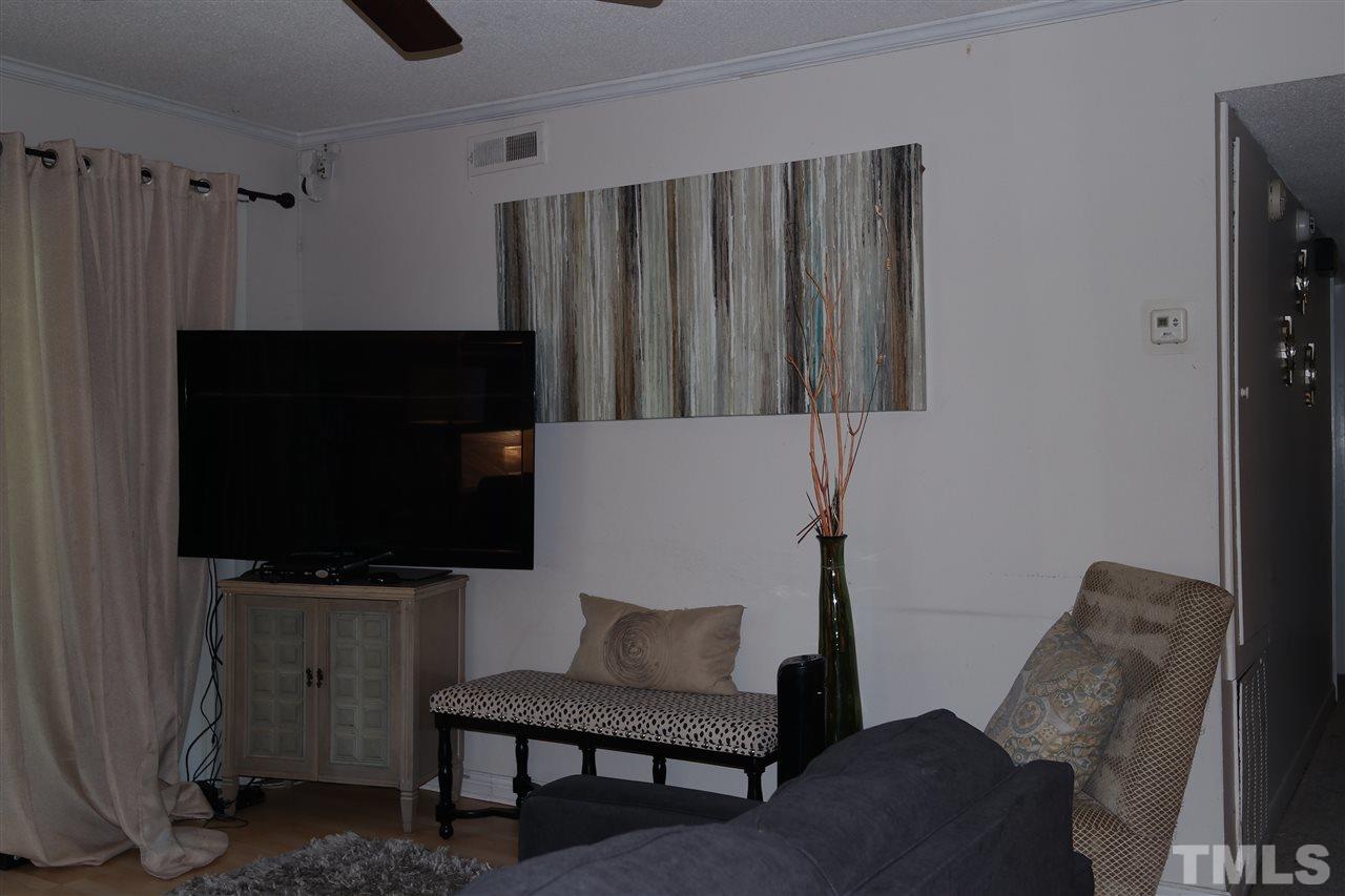5108 Flint Ridge Place, Unit 5108 Raleigh, NC 27609 - Photo 13 of 15 a living room with furniture and a flat screen tv