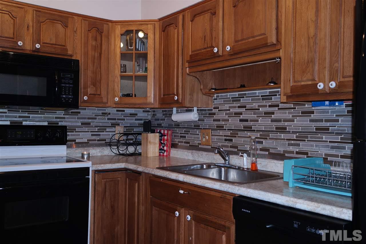 5108 Flint Ridge Place, Unit 5108 Raleigh, NC 27609 - Photo 5 of 15 a kitchen with stainless steel appliances granite countertop a sink stove and microwave