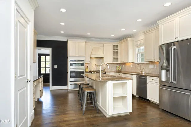 a kitchen with stainless steel appliances granite countertop a refrigerator and a stove top oven
