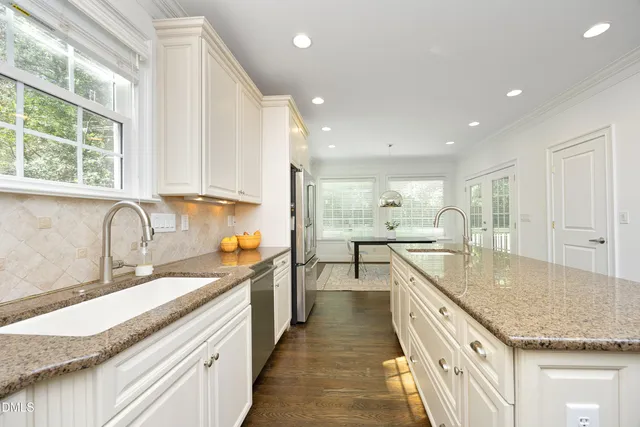 a view of a kitchen with kitchen island a sink a counter top space stainless steel appliances and windows