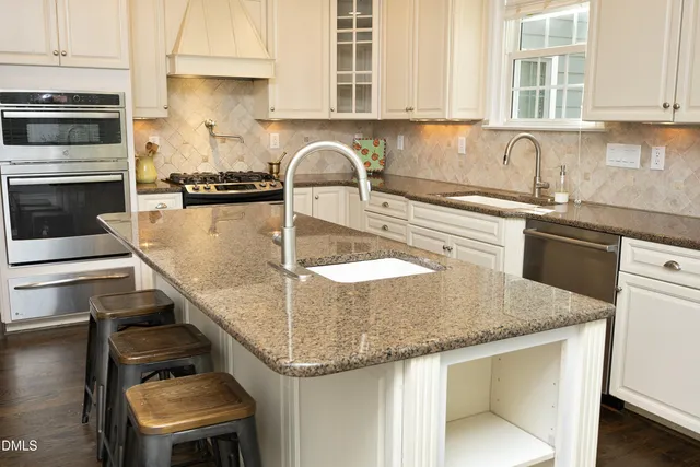a kitchen with a sink a stove and cabinets
