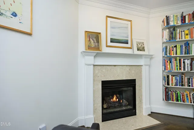 a living room with a fireplace and a book shelf