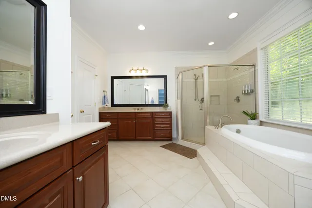 a spacious bathroom with a tub sink a mirror a vanity and a shower