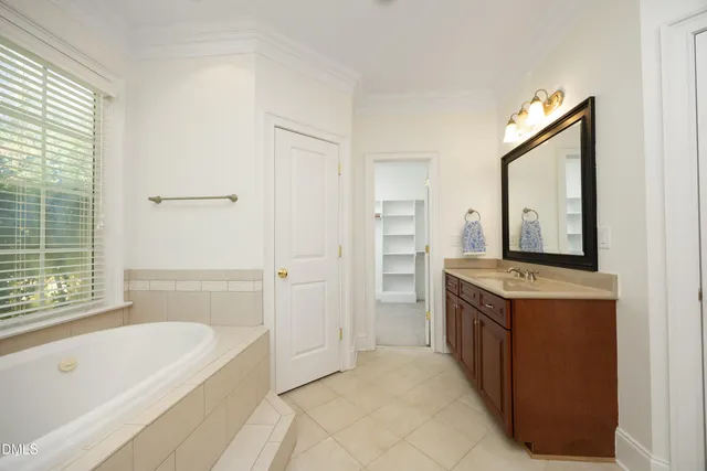 a bathroom with a tub sink shower and mirror