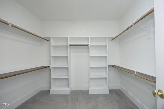 a view of walk in closet with empty racks