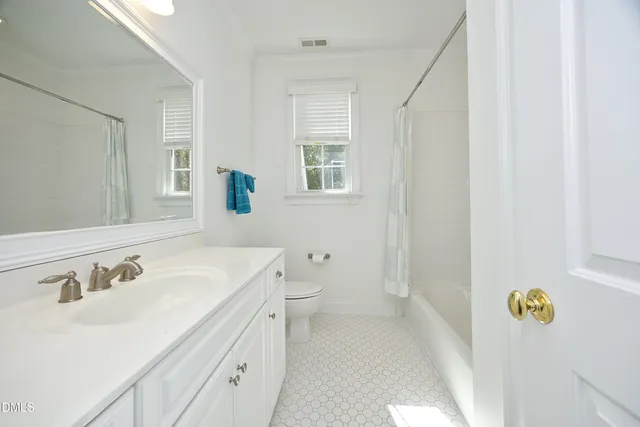a spacious bathroom with a sink a toilet and a mirror