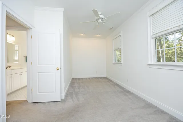 an empty room with windows and cabinet