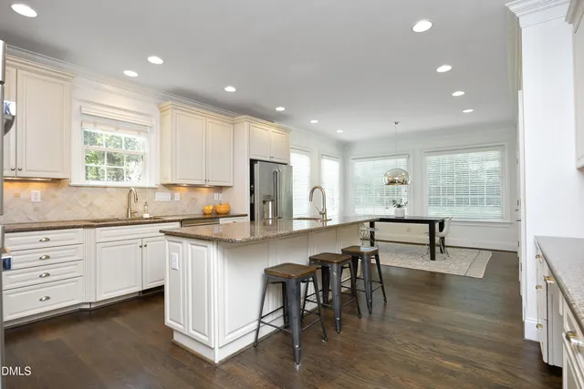 a kitchen with white cabinets and sink
