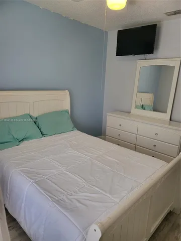 a bedroom with a bed and a television