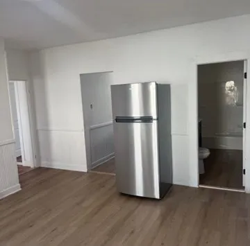 a view of empty room with wooden floor and cabinets