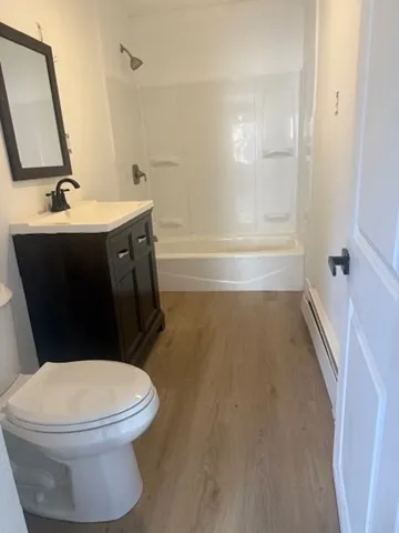 a bathroom with a sink a toilet a mirror and shower