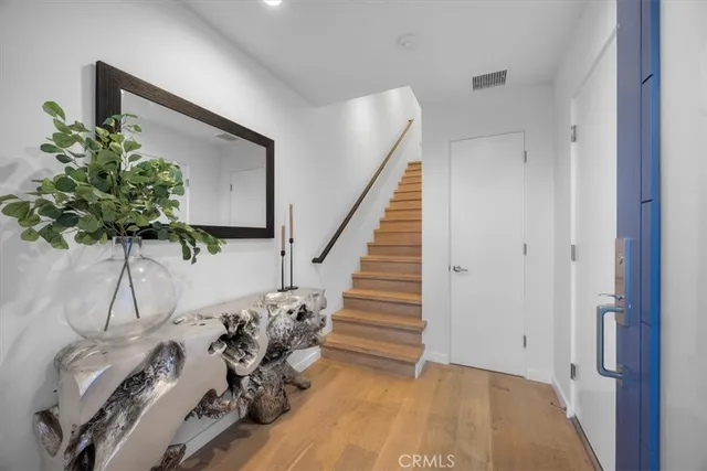 a view of a hallway with wooden floor and stairs