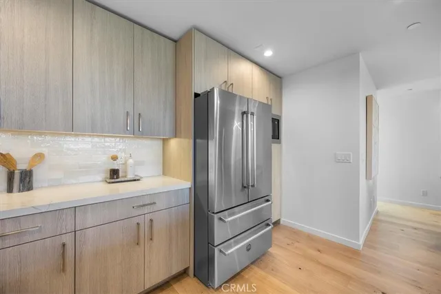 a kitchen with a refrigerator sink and cabinets