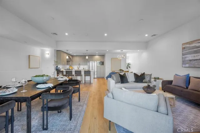 a living room with lots of furniture and view of kitchen