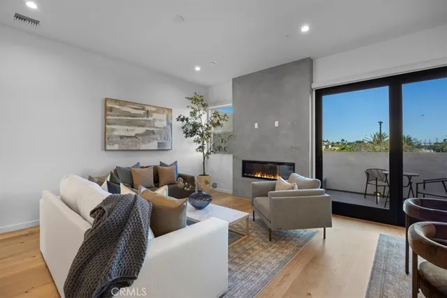 a living room with furniture floor to ceiling window and a flat screen tv