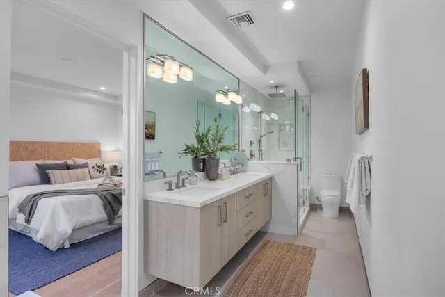 a en suite bathroom with a double vanity sink and a mirror