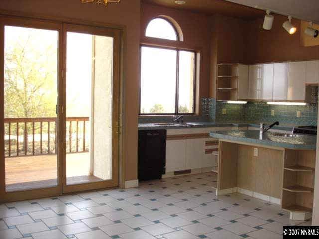 13277 Welcome Way Reno, NV 89511 - Photo 8 of 9 a kitchen with a sink a stove a microwave cabinets and dining table
