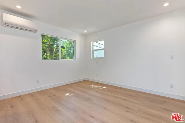 an empty room with wooden floor and window