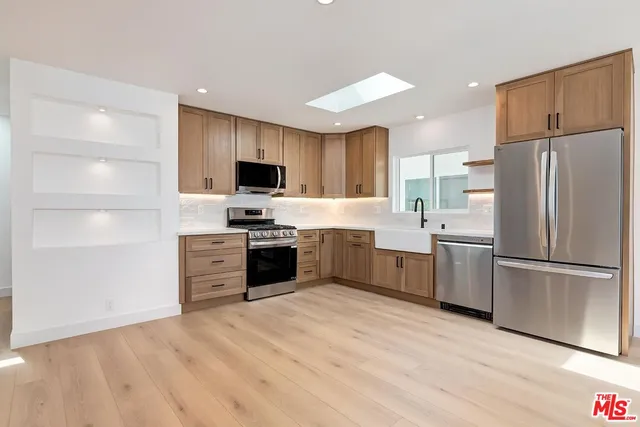 a kitchen with a refrigerator stove top oven and sink