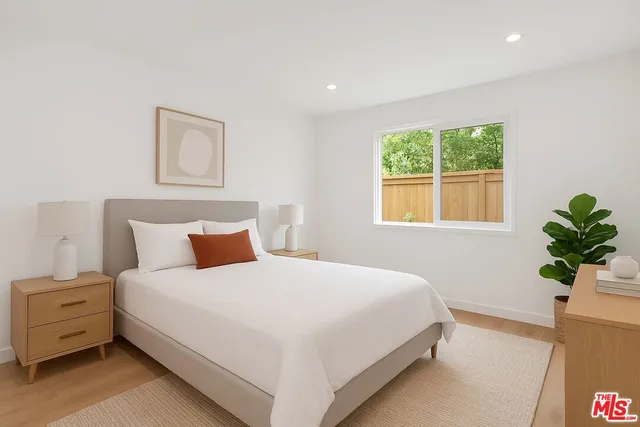 a large bed sitting in a bedroom next to a window