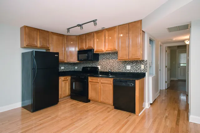 a kitchen with stainless steel appliances granite countertop a refrigerator and a stove top oven
