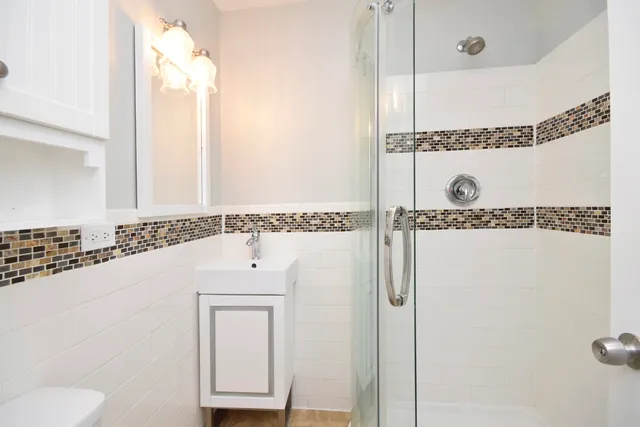 a bathroom with a shower a mirror and a sink