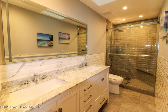 a bathroom with a granite countertop sink toilet and shower