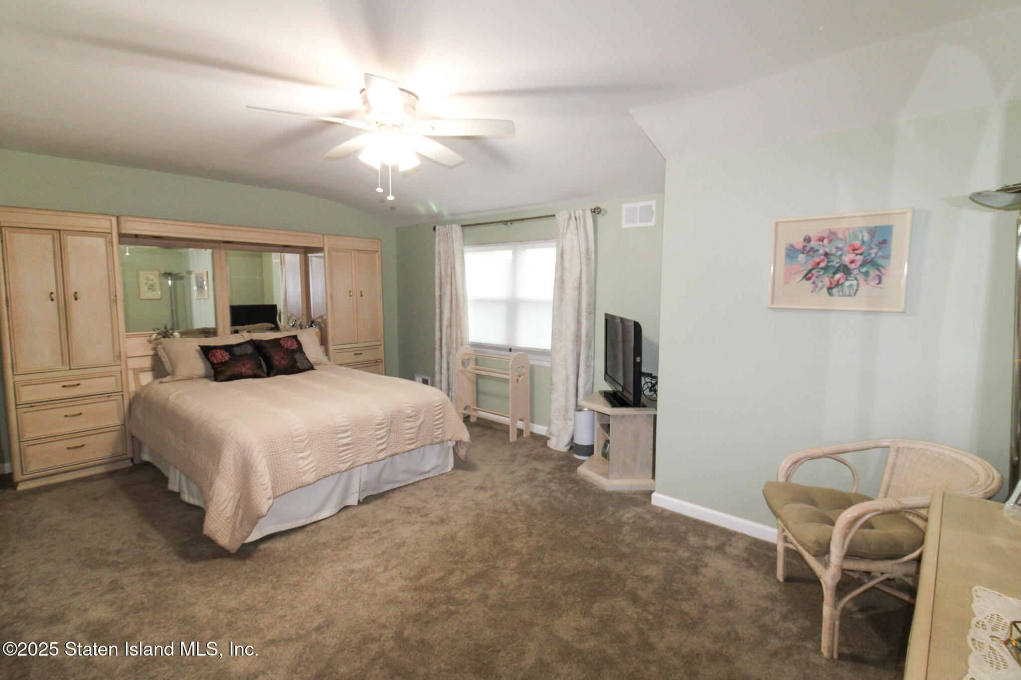 135 Freedom Avenue Staten Island, NY 10314 - Photo 15 of 29 a bedroom with a bed and a chandelier