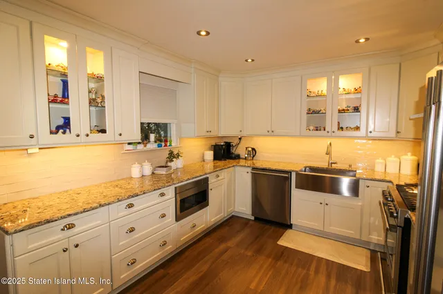 a large kitchen with stainless steel appliances granite countertop a lot of counter space and wooden floors