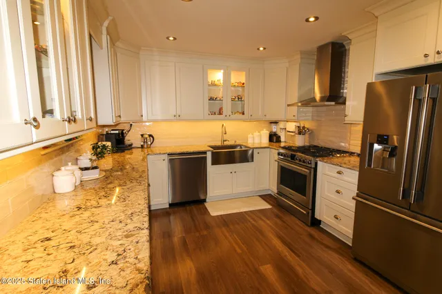 a kitchen with stainless steel appliances a stove a sink and a refrigerator