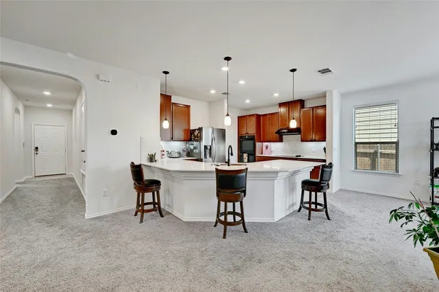 a large kitchen with a table and chairs