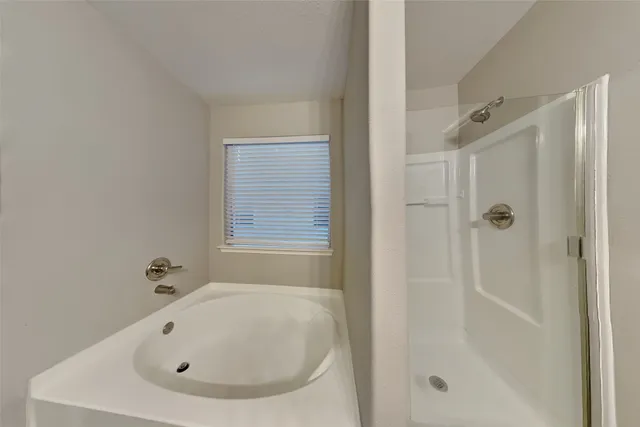 a white bath tub sitting next to a shower