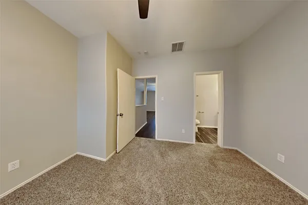 an empty room with closet and windows