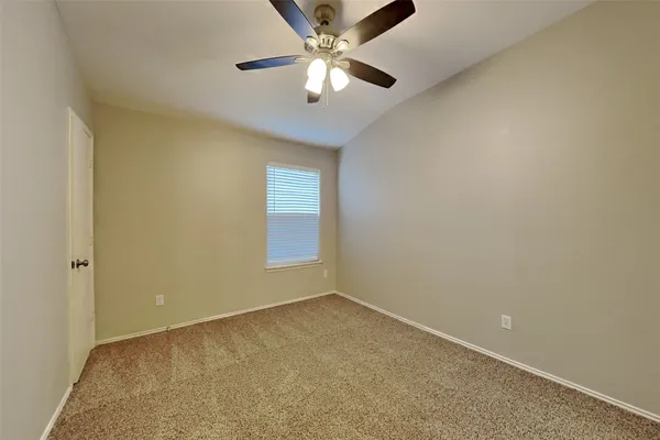 an empty room with a window and a fan