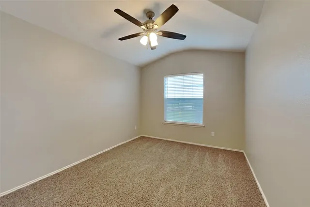 an empty room with a window and a ceiling fan